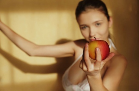Beautiful teen Mila unveils her full breasts while eating fruit