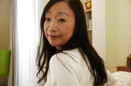 Mature Japanese woman Takako Miyai peeling off black stockings