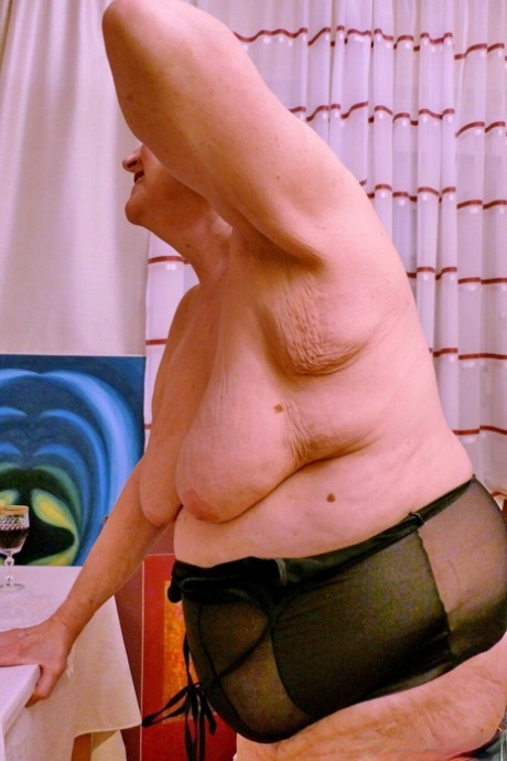 Horny fat granny Erla flaunts her big juggs and poses in red lacy stockings