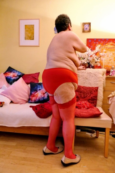 Horny fat granny Erla flaunts her big juggs and poses in red lacy stockings